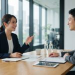 採用の相談をする日本人の企業担当者と代理店の担当者